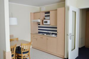 Una pequeña cocina con una mesa y un microondas. en Strandläufer App 205, en Zingst