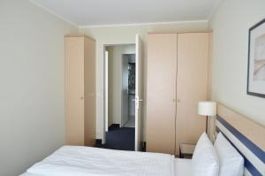 Habitación de hotel con cama y pasillo en Strandläufer App 205, en Zingst 13 fotos más
