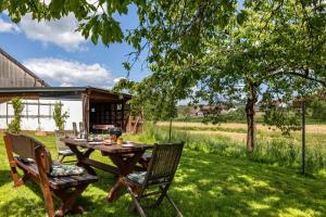 a picnic table and two chairs in the grass at Grashüpfer Plus bis 6 Pers in Freiensteinau