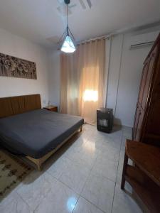a bedroom with a bed and a tv in it at Appartement au calme in Bir Kassa