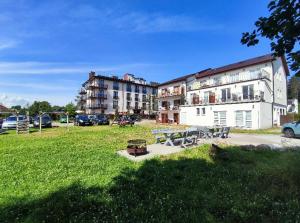 a park with a picnic table and a building at Hotelik Europa Apartamenty i pokoje gościnne in Unieście
