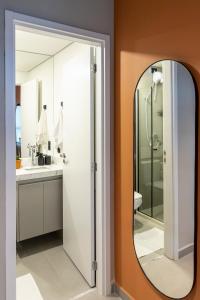 a bathroom with a shower and a mirror at Loft Marília City in Marília