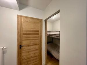 Zimmer mit Holztür und Etagenbett in der Unterkunft Homency - Résidence Fermes de l'Alpe C101 in L'Alpe-d'Huez