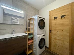 ein Badezimmer mit Waschmaschine und Waschbecken in der Unterkunft Homency - Résidence Fermes de l'Alpe C101 in L'Alpe-d'Huez + 7 Fotos