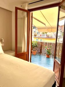 a bedroom with a bed and a balcony with plants at Casa Camilla in Riomaggiore