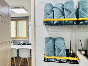 a bunch of towels are on shelves in a room at Snug J House in Seoul