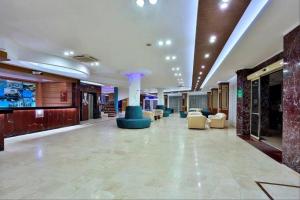 a lobby with couches and chairs in a building at Club Mirabell hotel in Elikesik