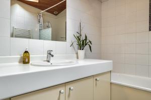 a white bathroom with a sink and a mirror at A Bordeaux, Climatisée avec billard in Le Bouscat +15 photos