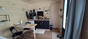 a small kitchen with a table and chairs in a room at La tiny house in Saint-Vincent-de-Paul +14 photos