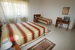 a bedroom with two beds and a desk and a chair at B&B La Ganzaria in San Michele di Ganzaria
