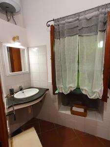 un bagno con lavandino e tenda da doccia di Casa Lavinia - open space con terrazza privata a Città di Lipari Altre 20 foto