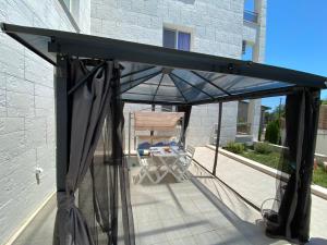 Un dosel negro sobre una silla en un patio. en Byala Leisure Place, en Byala 6 fotos más