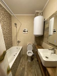 Un baño con bañera, inodoro y lavabo. en Byala Leisure Place, en Byala