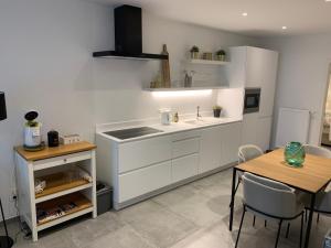 a kitchen with a sink and a table with chairs at Francis50 in Ostend