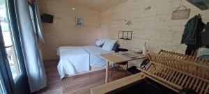 a small room with a bed and a table at La tiny house in Saint-Vincent-de-Paul