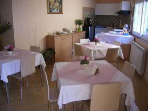 a dining room with tables and chairs and a kitchen at B&B La Ganzaria in San Michele di Ganzaria