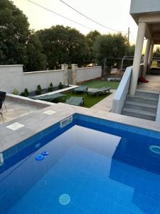 a large blue swimming pool in a backyard at MM Villa, Strandnahe Villa mit Pool & Whirlpool in Kruševo in Kruševo
