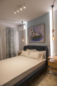 a bedroom with a bed with a painting on the wall at Para Thin Alos Skiathos in Skiathos