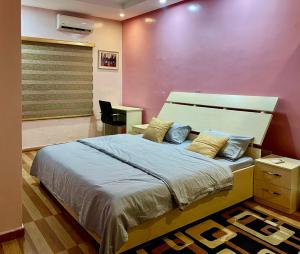 レッキにあるHeosh Apartmentの紫の壁のベッドルーム1室(大型ベッド1台付)