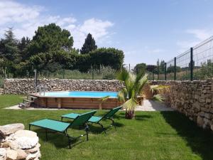 a pool in a yard with two chairs and a palm tree at La maison de la détente in Mondragon