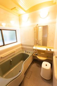 a bathroom with a tub and a toilet and a sink at Halo in Oshima +8 photos