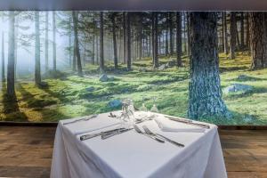 a table in front of a painting of a forest at Hôtel Campo Dell'oro in Ajaccio