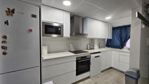 una cucina con mobili bianchi e un frigorifero di Bungalow Morro de Gos II REF 054 a Oropesa del Mar