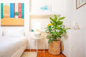 a living room with a white couch and a vase with a plant at GuestReady - Sintra Cosy House in Sintra