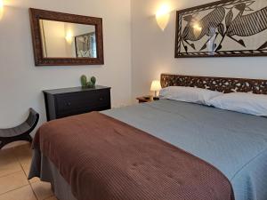 Un dormitorio con una cama con un espejo y una silla. en Villa de la Paz, en Playa Blanca 21 fotos más