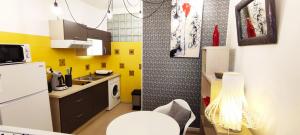 a small kitchen with yellow walls and a white refrigerator at Cosy-2 pers-Coeur de ville-Proche Bd Pyrénées in Pau