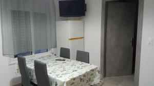a dining room with a table and chairs and a television at Elea House 2 in Keramoti