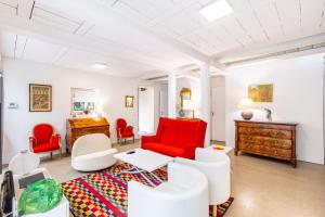 a living room with a red couch and chairs at GuestReady - Charming haven with a private garden in Nogent-sur-Marne +21 photos