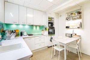 a kitchen with white cabinets and a table at GuestReady - Charming haven with a private garden in Nogent-sur-Marne