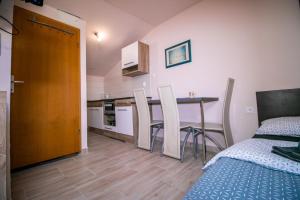 a room with a bed and a table and a kitchen at Apartment Jug in Piran