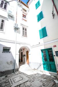a building with a green door in a courtyard at Apartment Jug in Piran