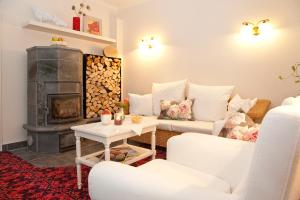 a living room with a fireplace and white furniture at Pension Vitalis in Willingen
