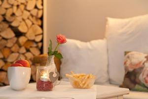 a table with a vase with a rose and snacks on it at Pension Vitalis in Willingen