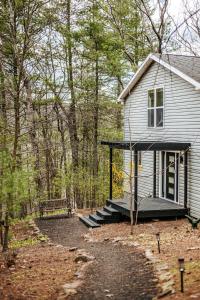a small house with a porch and stairs to it at Two Forest Cabins,Decks,Fire Pit,Hot Tubs,GameRoom in Berkeley Springs
