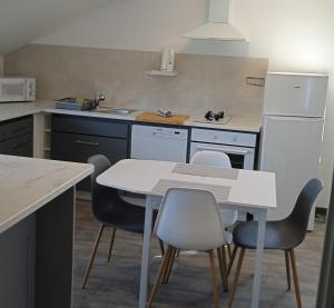 a kitchen with a white table and chairs at gite des palmiers in Ameugny
