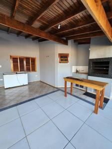a kitchen with a wooden table in a room at Casa grande com piscina Chácara do Dinho in Londrina
