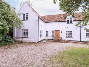 an exterior view of a white house with a driveway at White House Cottage in Fakenham