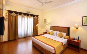 a hotel room with a bed and a television at Royal Court in Madurai