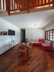 a living room with a red couch and a table at Casa grande com piscina Chácara do Dinho in Londrina