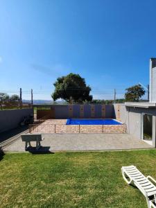 a backyard with a picnic table and a swimming pool at Casa grande com piscina Chácara do Dinho in Londrina