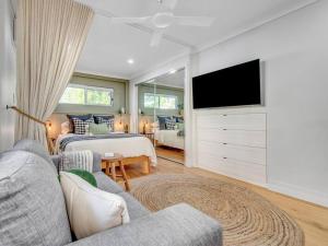 Una sala de estar con un sofá y un televisor. en Comfort Cove - quiet luxury with full kitchen, en Brisbane