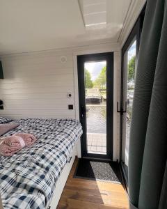 a bedroom with two beds and a door to a window at Svencele Boats laivai-namai kuriems nereikia laivavedžio teisių in Svencelė