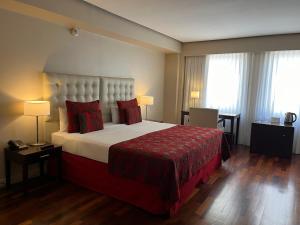 a hotel room with a large bed with red pillows at Kenton Palace Buenos Aires in Buenos Aires +27 photos