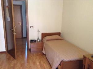 a small bedroom with a bed and a wooden floor at Hotel Galles in Paluzza