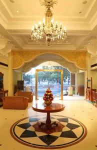 a large lobby with a table and a chandelier at Royal Court in Madurai
