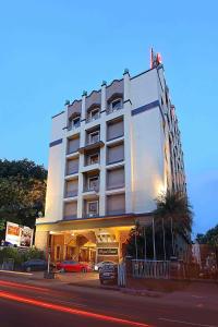 a large white building with cars parked in front of it at Royal Court in Madurai